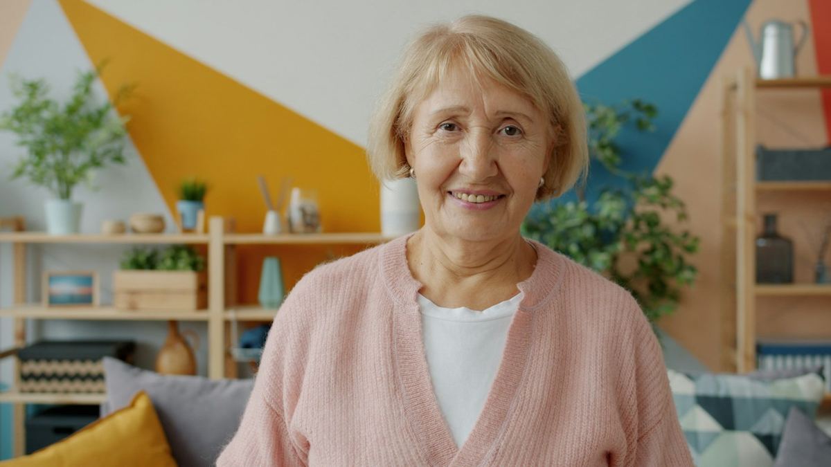 An older woman smiling in her living room